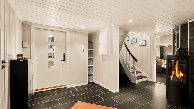 En romslig hall med trapp til hovedetasjen og adkomst til øvrige rom i underetasjen.