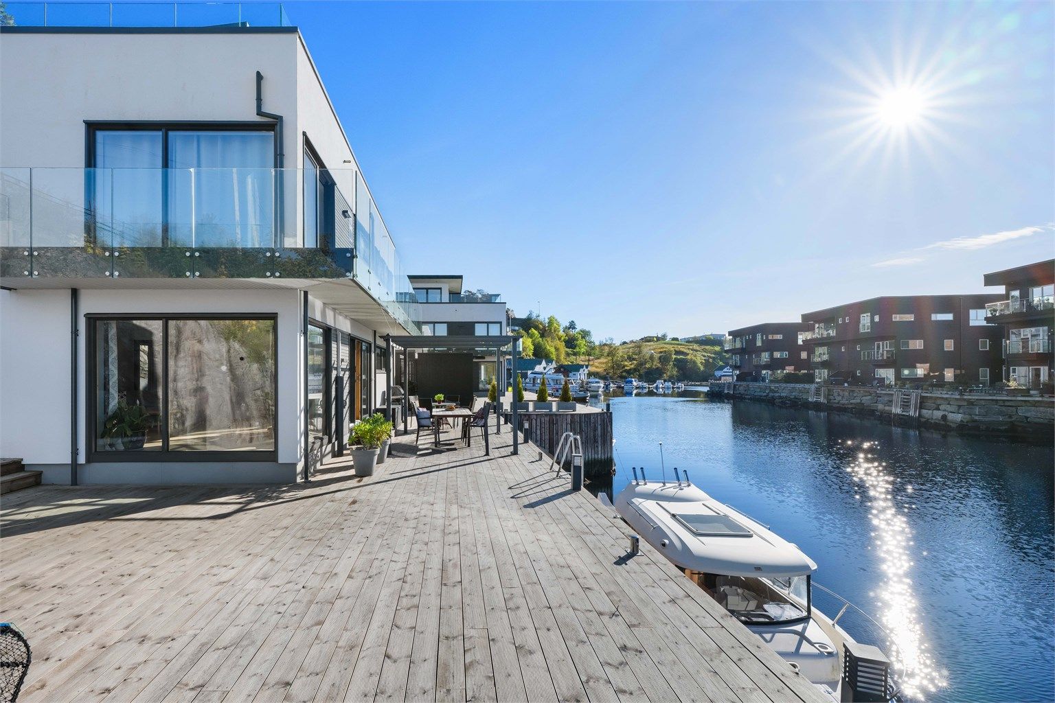 Det solide bryggeanlegget strekker seg langs hele boligens fasade mot sjøen. Båten kan ligge fortøyd langs husveggen hele året.