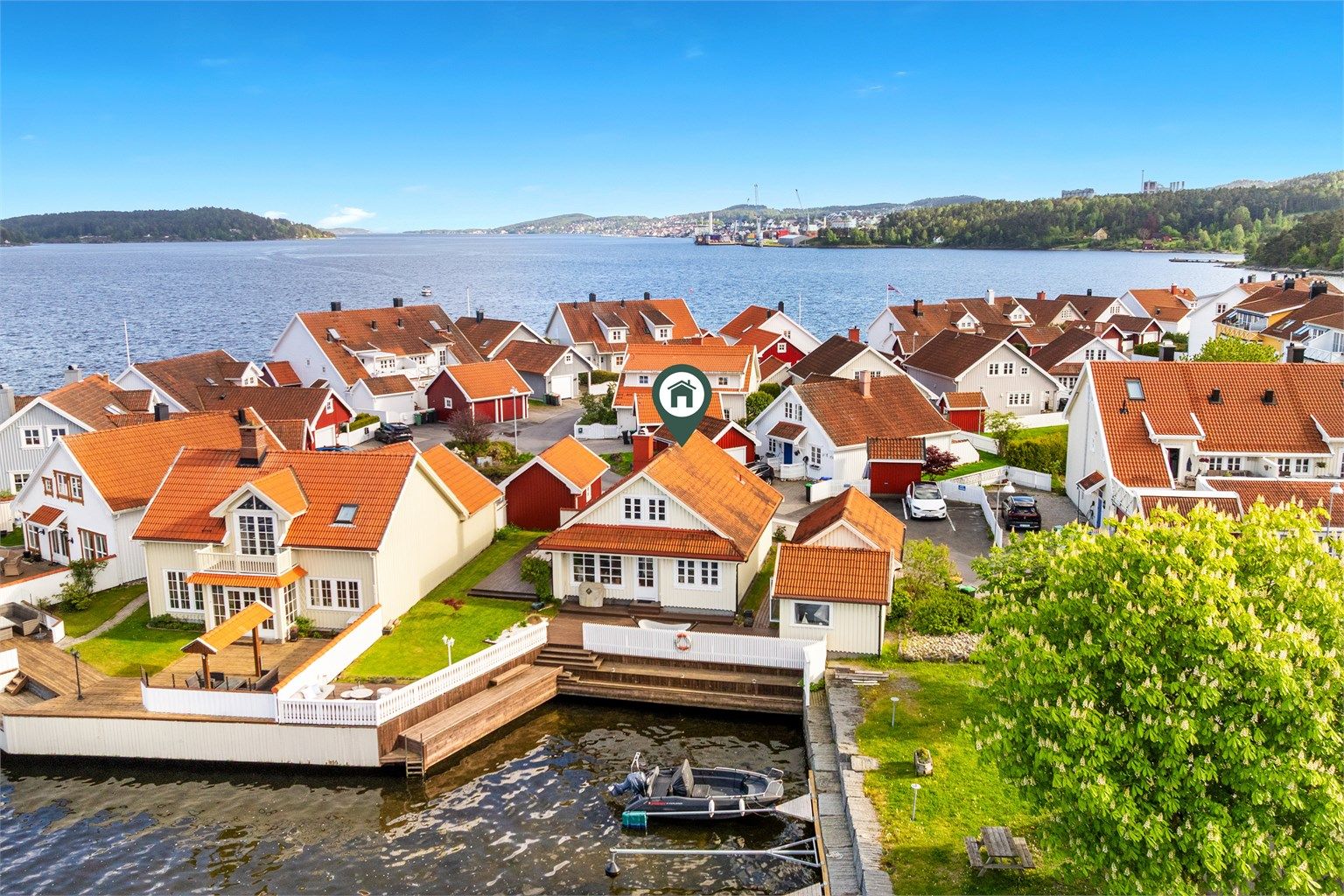 Vakkert i vannkanten med egen brygge, garasje, sjøbod og helhetlig fargeskala.