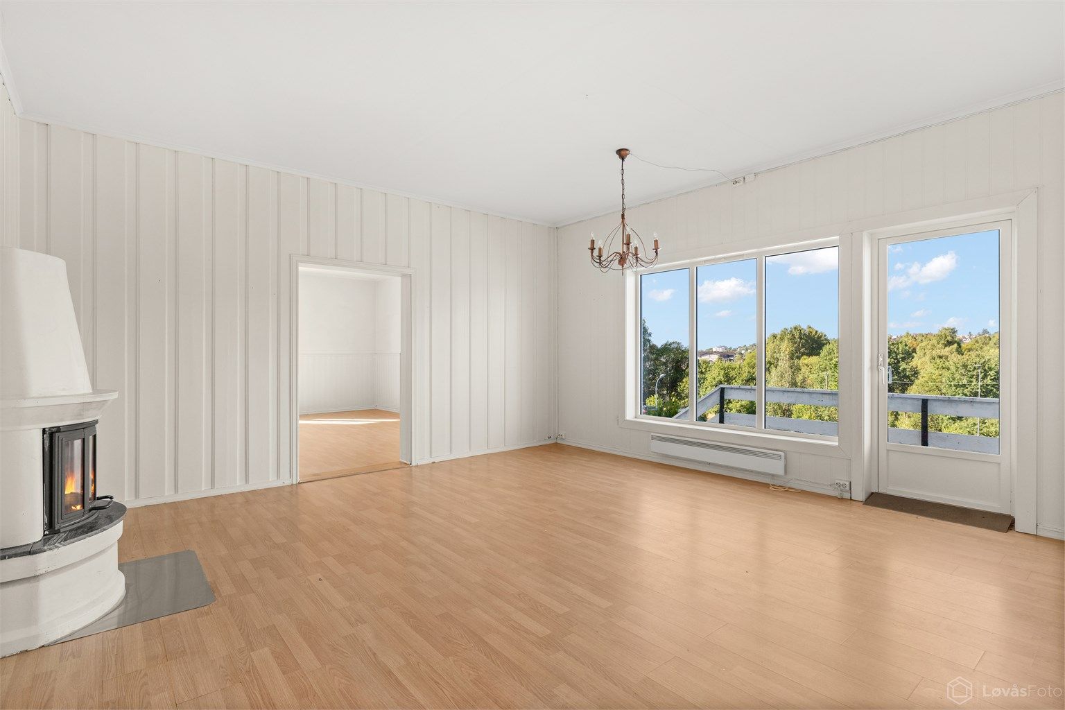 Lys stue med stemningsfull peisovn og direkte utgang til terrassen.
Foto: Løvås Foto