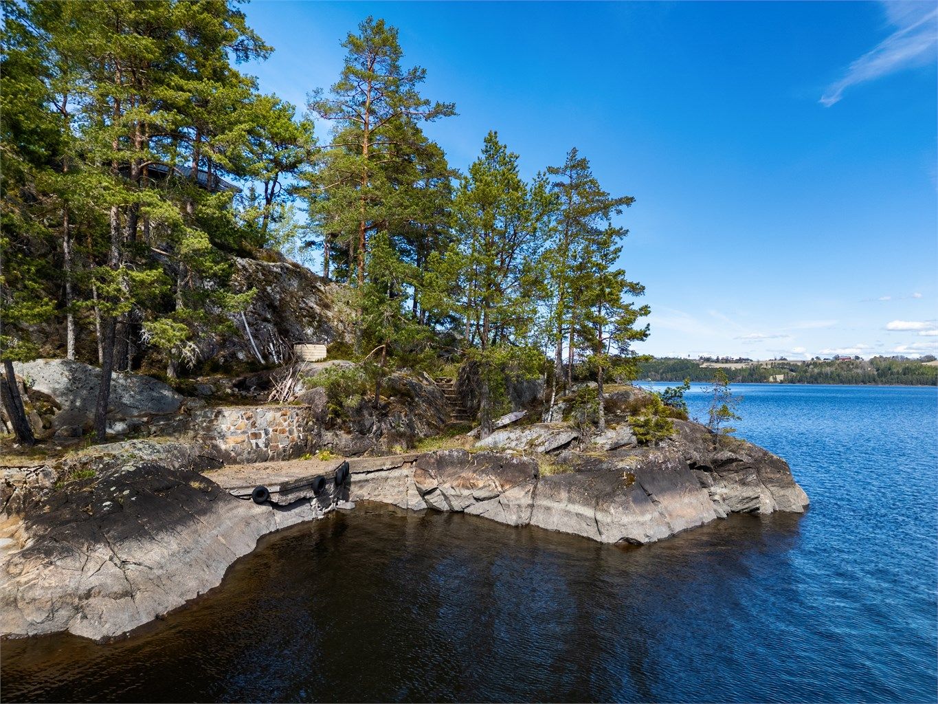 Det er støpt opp egen brygg på nede ved vannet samt fine svaberg som frister ved varme sommerdager