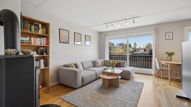 Leiligheten fremstår lys og innbydende med store vindusflater som slipper inn rikelig med dagslys. En praktisk hev- og skyvedør leder ut til balkongen og bidrar til en luftig romfølelse, samtidig som den gir en naturlig overgang mellom inne- og utearealet