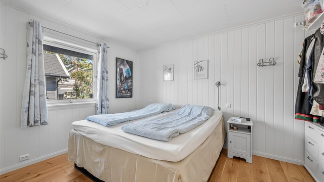 Soverom i første etasje med parkettgulv og plass til dobbeltseng.