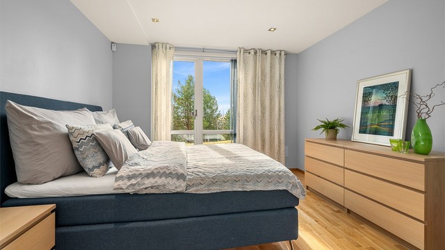 Soverom 3 er på 13,5 kvm og fremstår romslig og harmonisk, med gode møbleringsmuligheter og direkte tilgang til en lun uteplass på bakkeplan.