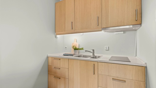 Kjøkkenet er utstyrt med integrert platetopp, komfyrvakt og ventilator i overskap.