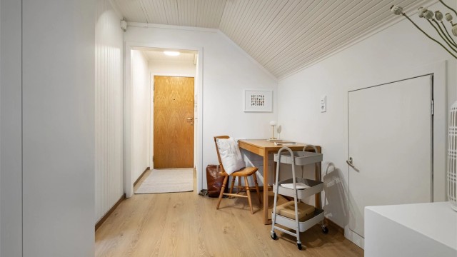 Lys og romslig gang med malte vegg- og himlingsflater og laminat på gulv