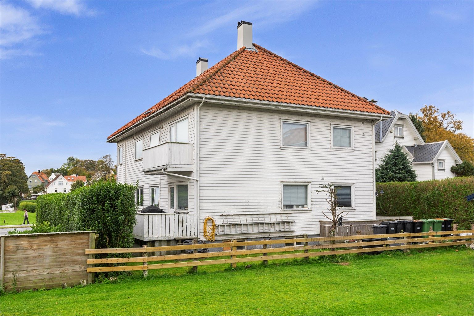 Inngjerdet tomt med felles plenareal og hekk rundt eiendommen.