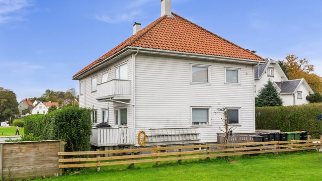 Inngjerdet tomt med felles plenareal og hekk rundt eiendommen.