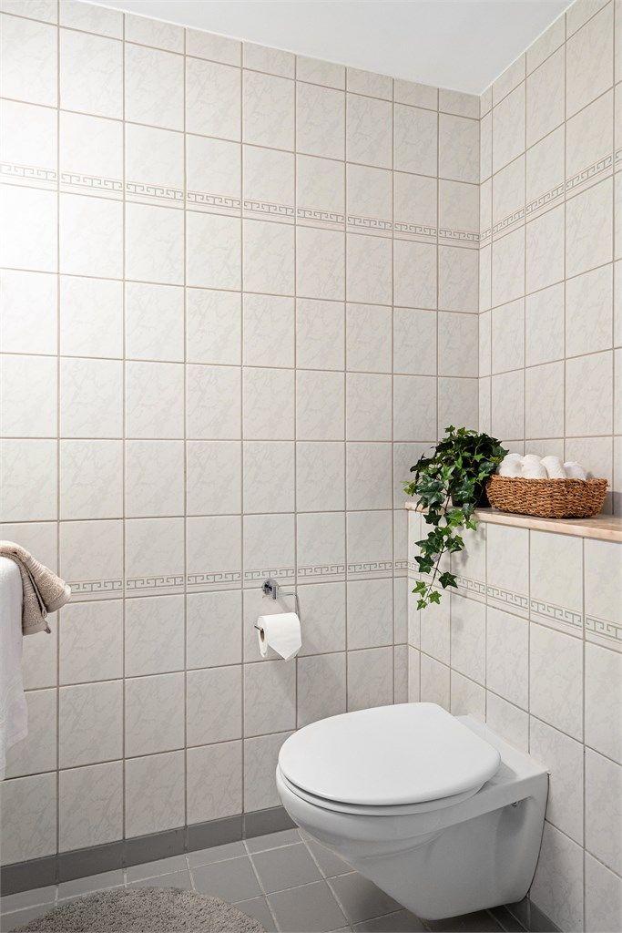 Gjestewc er helfliset med varme i gulv. Enkel servant, speil på vegg og vegghengt toalett. 