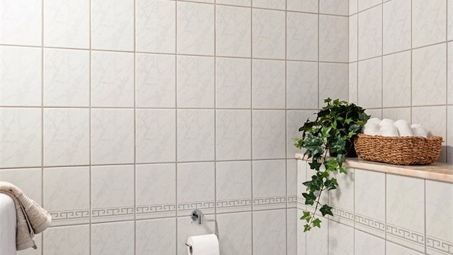 Gjestewc er helfliset med varme i gulv. Enkel servant, speil på vegg og vegghengt toalett.