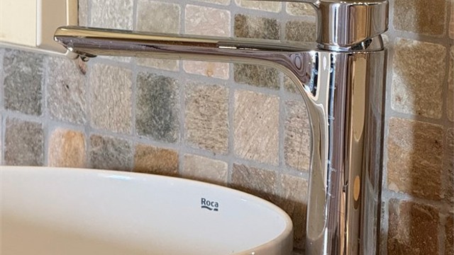 Detaljer som mosaikkfliser og moderne armaturer understreker standarden på badet