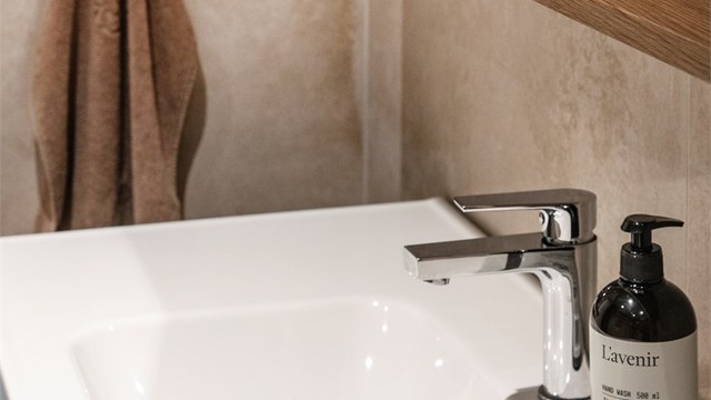 Servantinnredningen har slette fronter og heldekkende servant med ett-greps armatur.