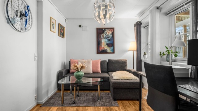 Koselig kjellerstue/kontor med vinduer under terrassen.