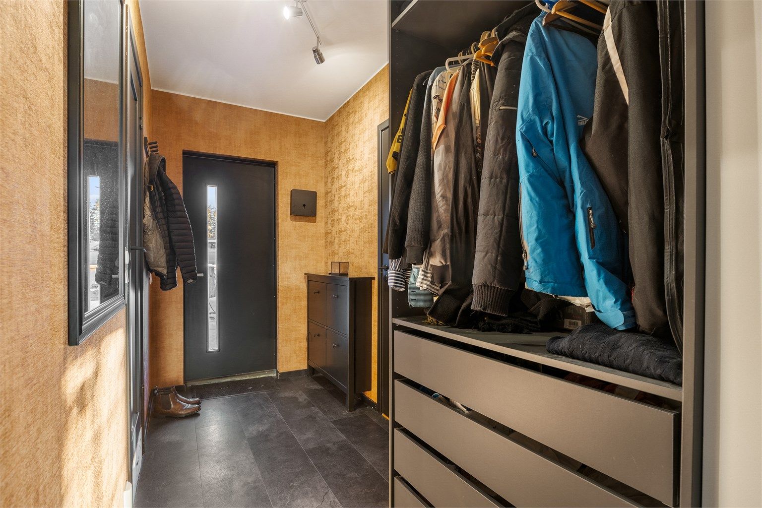 Entré med praktisk utforming og plass til oppheng og oppbevaring av yttertøy og sko. 