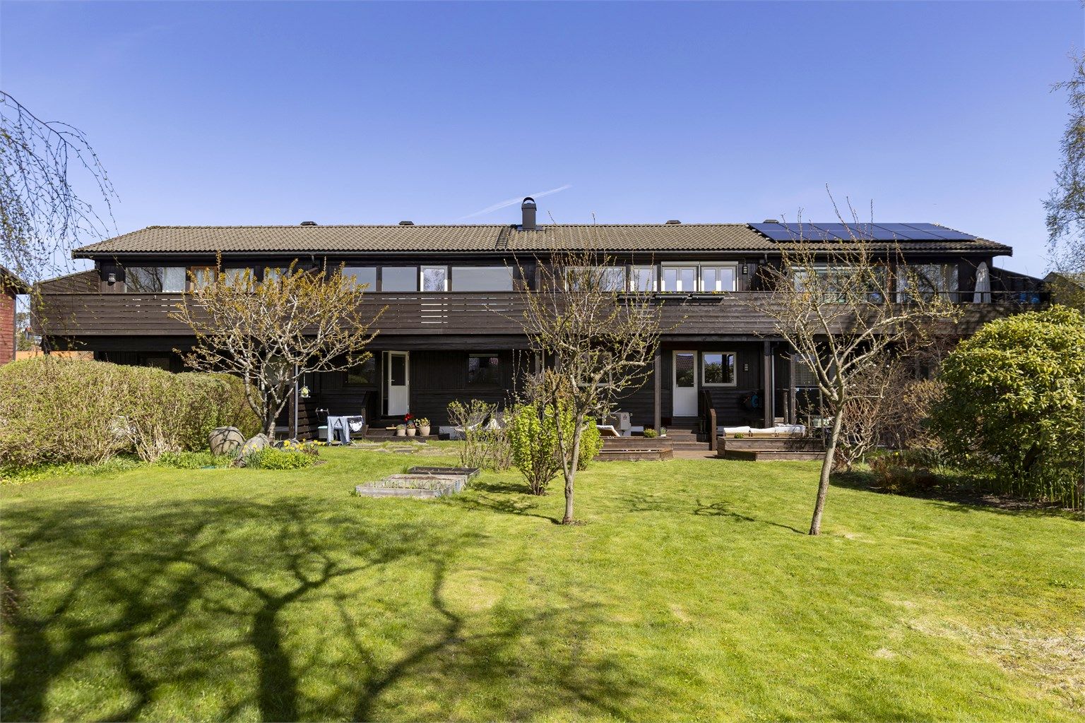 Den store felleshagen er pent opparbeidet med plen og diverse beplantning.