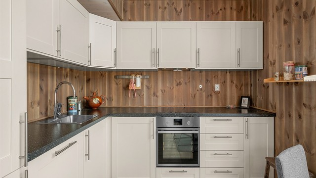 Moderne kjøkken fra 2018 med innredning fra Nordlyshytter, integrerte hvitevarer og praktiske arbeidsflater.