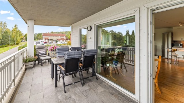 Romslig overbygget balkong ut fra stue.