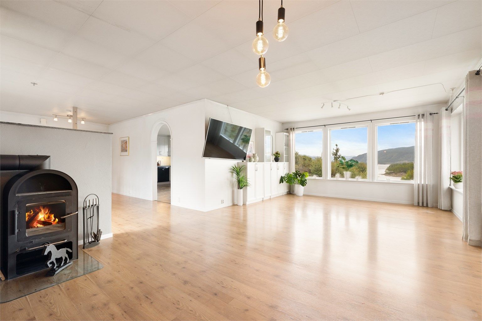 Romslig stue med flott sjøutsikt. Vedovnen skaper en varm og trivelig ramme på kalde dager.