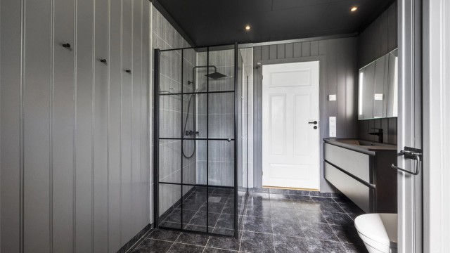 Badet er oppgradert med nyere innredning og har en romslig dusjnisje med glassvegger.