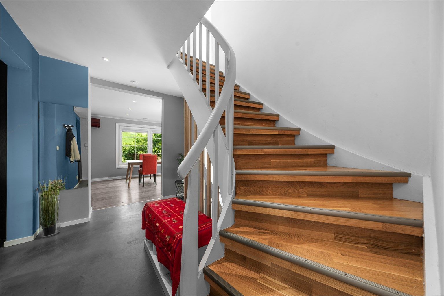 Den svingte trappen i tre er et sentralt og elegant element i boligen.