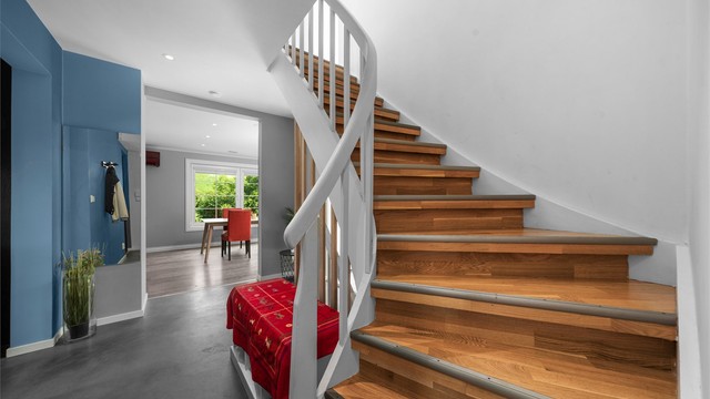 Den svingte trappen i tre er et sentralt og elegant element i boligen.