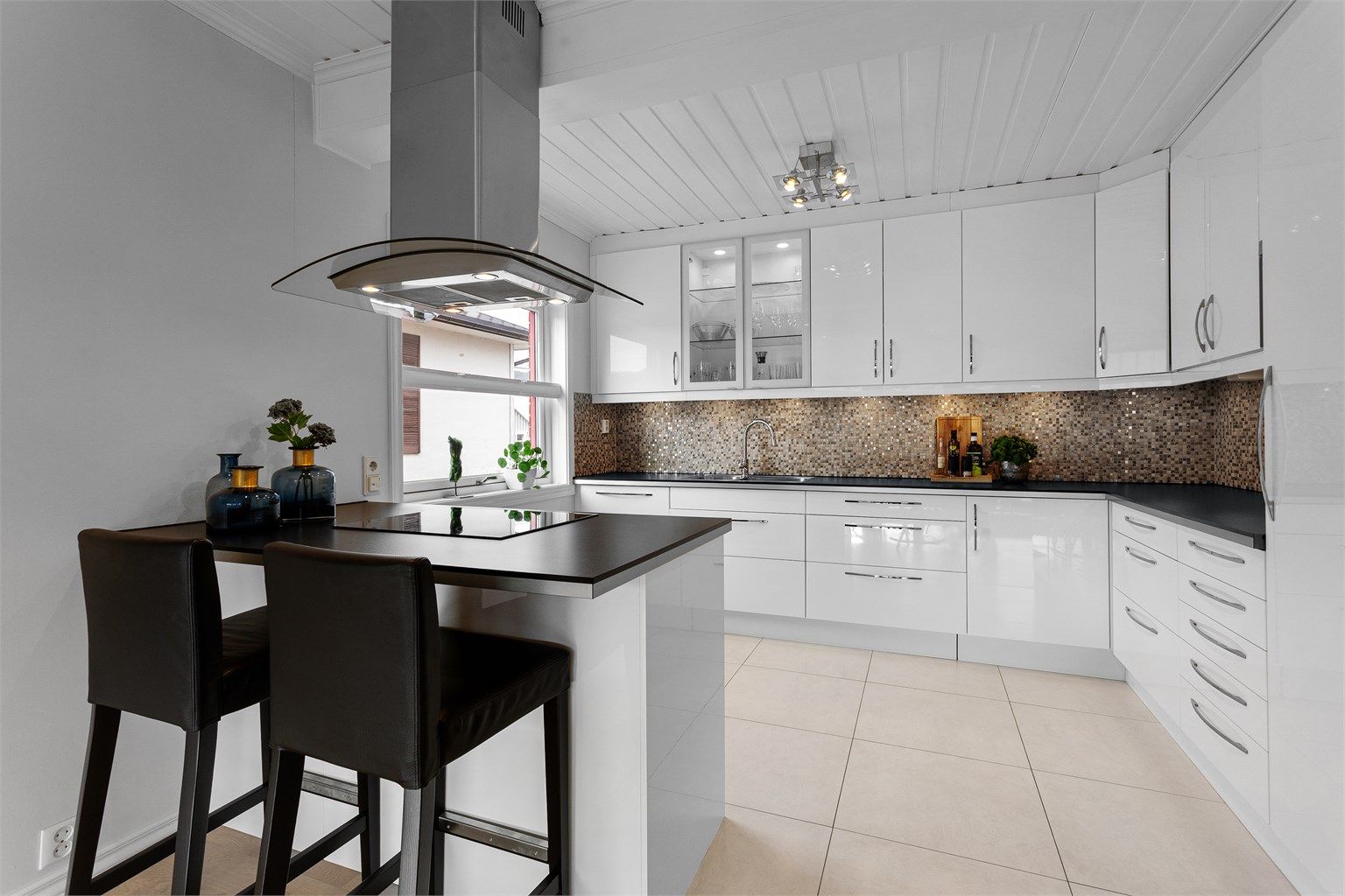 Pent kjøkken med høyglanset IKEA kjøkkeninnredning og integrerte hvitevarer