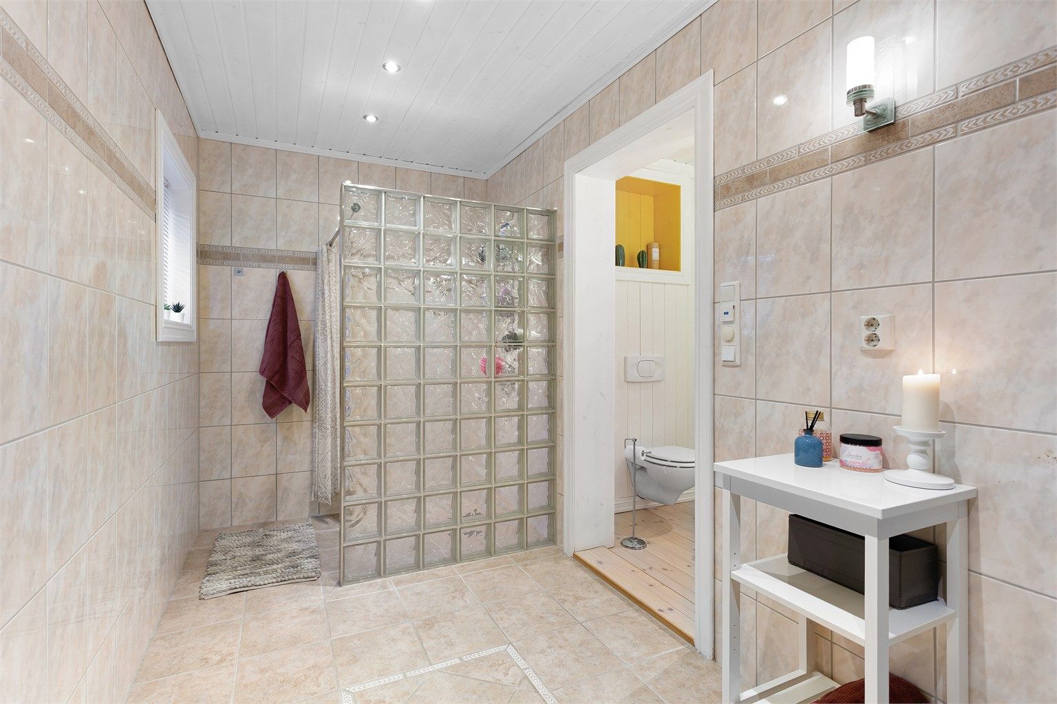 Den andre delen av badet har flislagt gulv og flislagte vegger. Egen dusjdel med gulvvarme og badekar. 