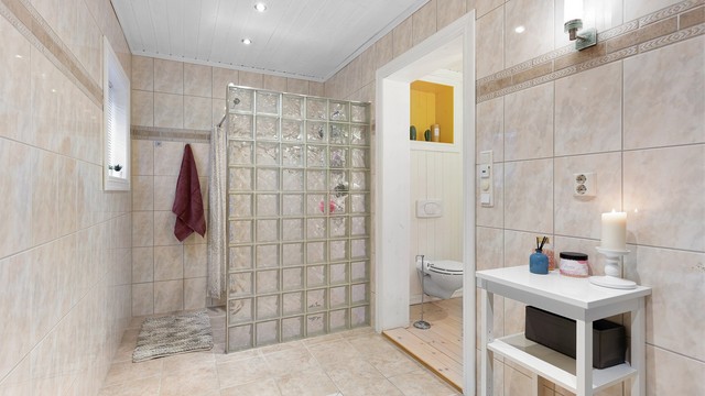 Den andre delen av badet har flislagt gulv og flislagte vegger. Egen dusjdel med gulvvarme og badekar.