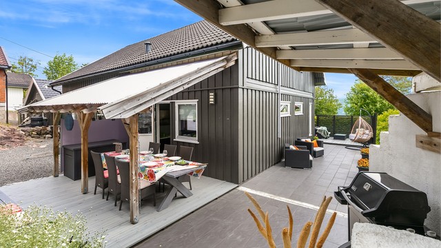 Ved den overbygde uteplassen med adkomst fra stua er det også laget en koselig overbygg hvor grill mm kan trakteres