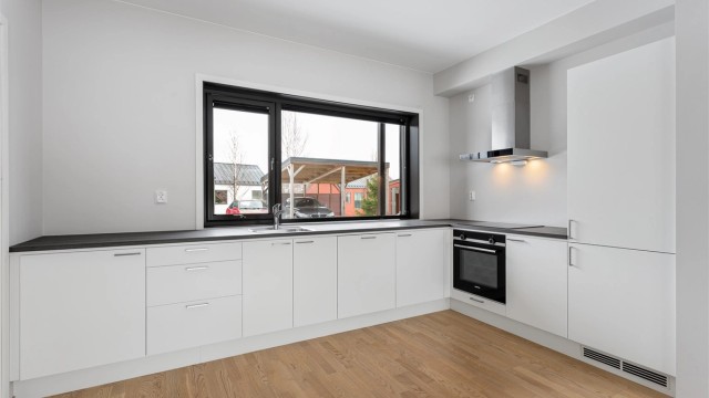 Innredningen har glatte fronter og slitesterke benkeplater i laminat med god arbeidsplass.