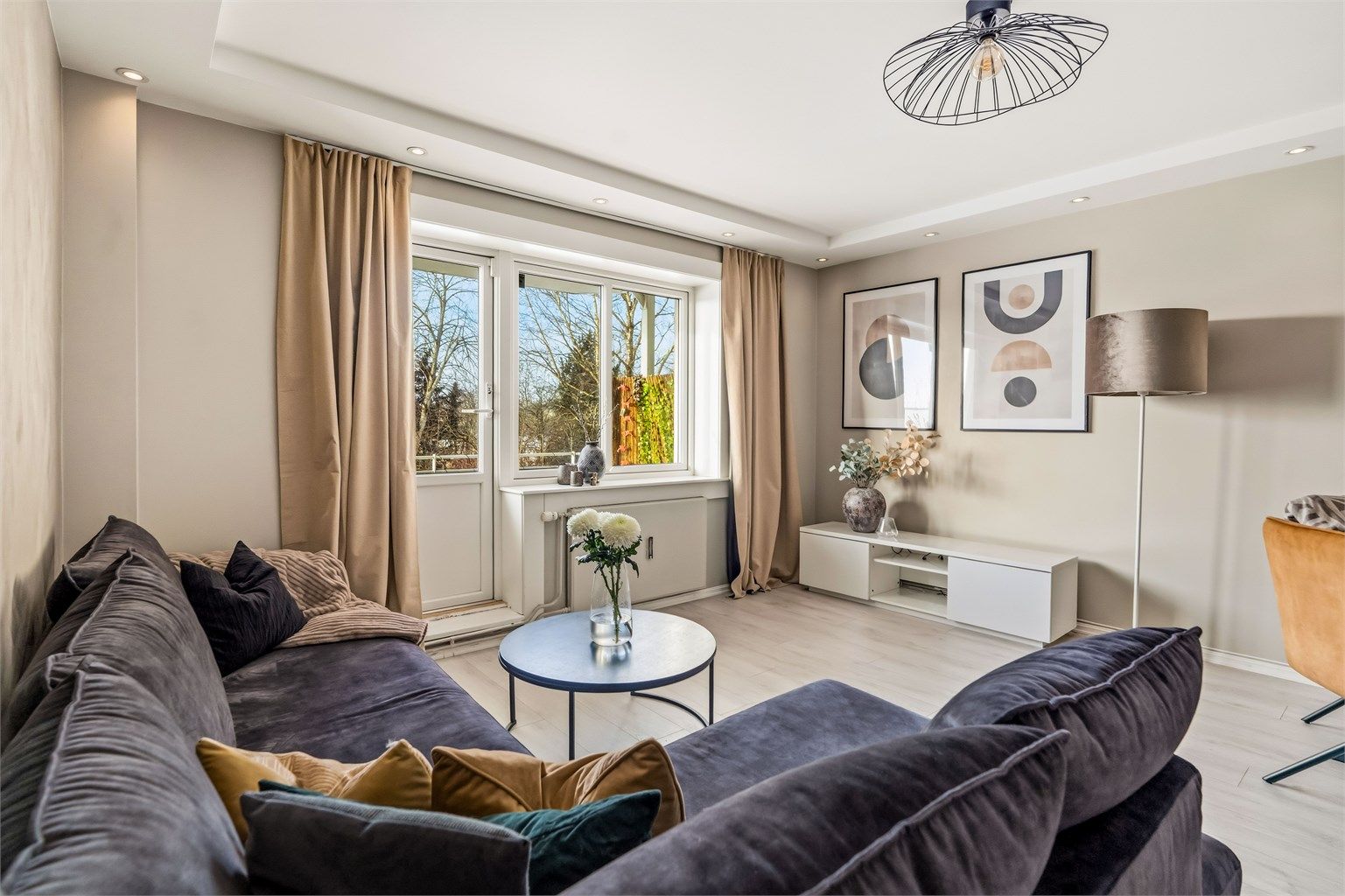 Stuen er lys og romslig med malte flater og downlights i nedsenket del av himlingen