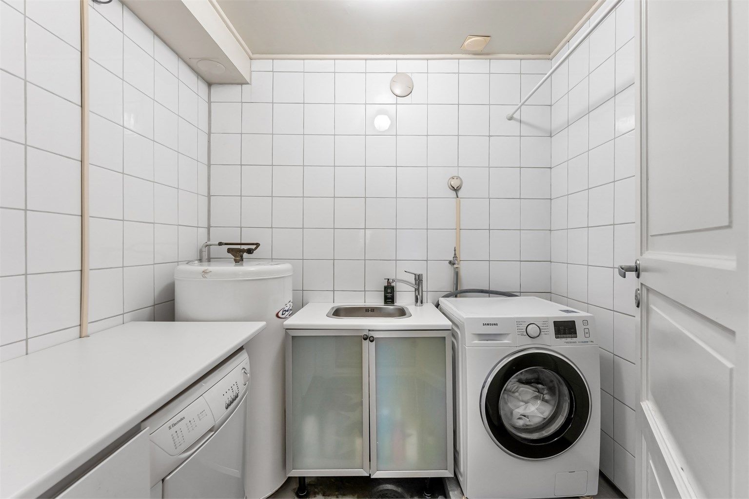 Praktisk, separat vaskerom med utslagsvask og opplegg for vaskemaskin. Her er også varmtvannsberederen plassert.
