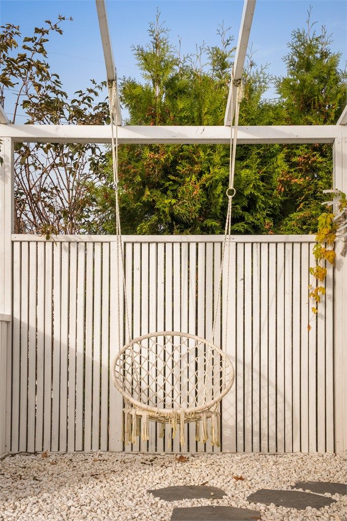 Flott pergola med halvvegger og steinbelagt dekke på terrassen.