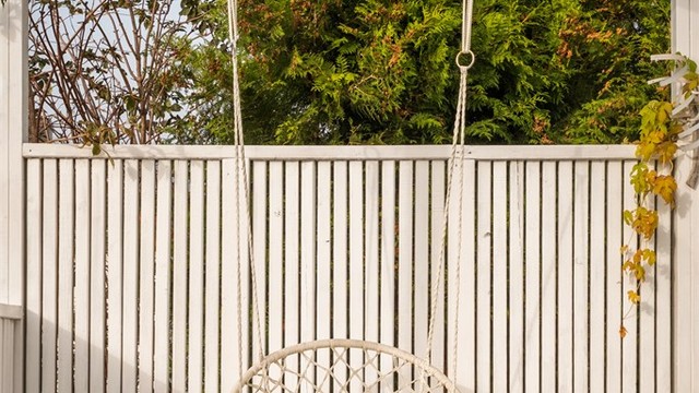 Flott pergola med halvvegger og steinbelagt dekke på terrassen.