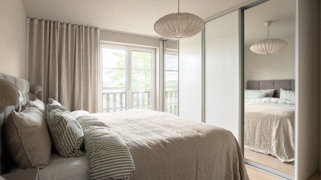 En stor skyvedørsgarderobe med speilfronter gir rikelig med oppbevaringsplass.