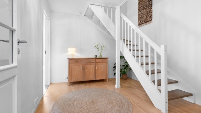 Hallen binder sammen rommene i første etasje og har en malt innvendig tretrapp fra byggeåret