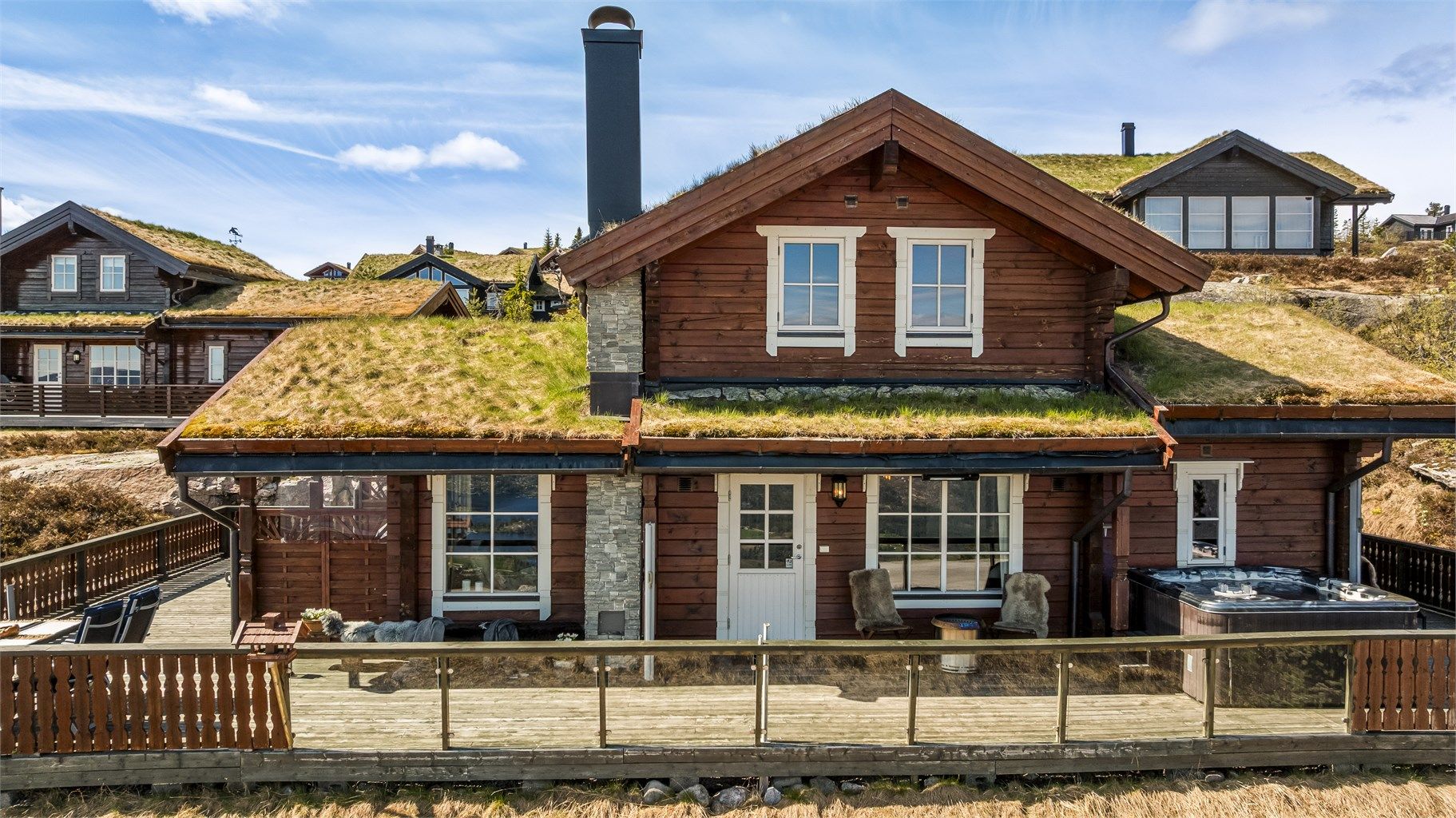 Fasaden er kledd med laftet tømmer og har detaljer i stein.