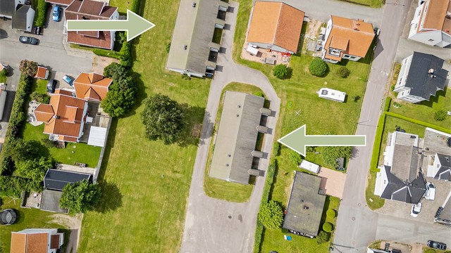 Den store, flate tomten på ca. 3,8 mål, ligger i et etablert boligområde med nærhet til fjorden.