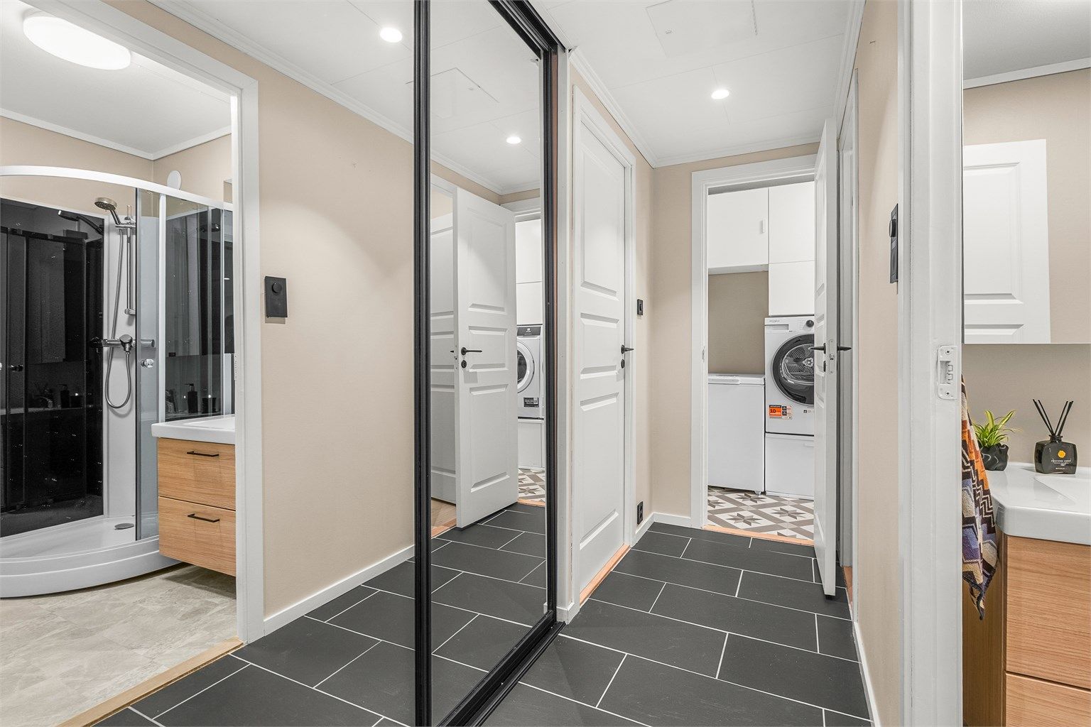 Romslig entré med praktisk plassbygd skyvedørsgarderobe. 