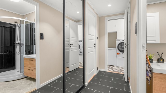 Romslig entré med praktisk plassbygd skyvedørsgarderobe.