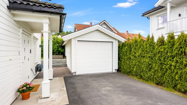Asfaltert gårdsplass og frittstående garasje på 19 m² fra 2017.