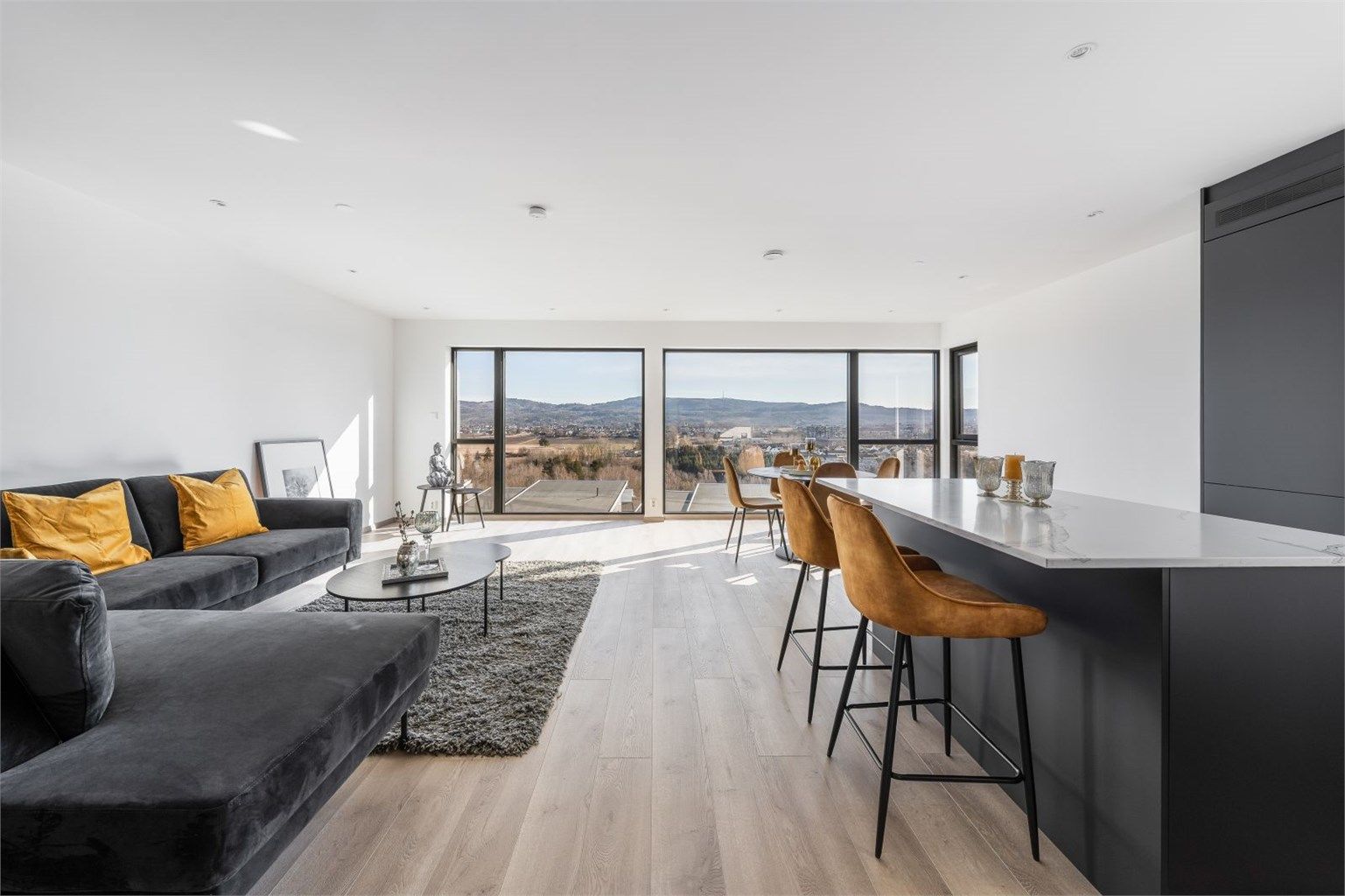 Åpen stue-kjøkkenløsning med store vinduer som gir rikelig med naturlig lys. Foto: Joakim Mylove -Inbovi Foto