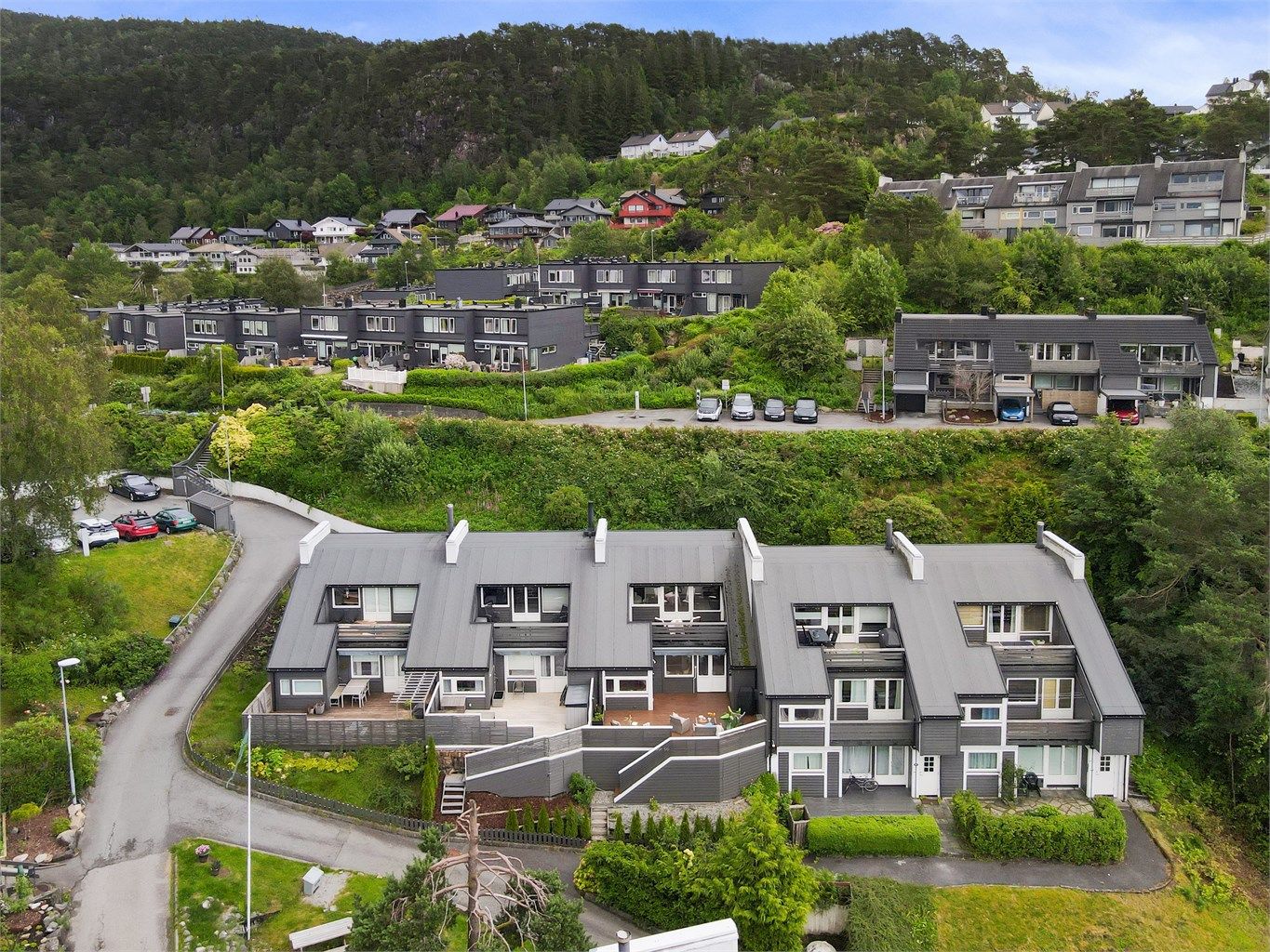 Huset ligger i midten av en rekke på 5 og har 2 vestvendte uteplasser og en uteplass i øst ved inngangsparti.