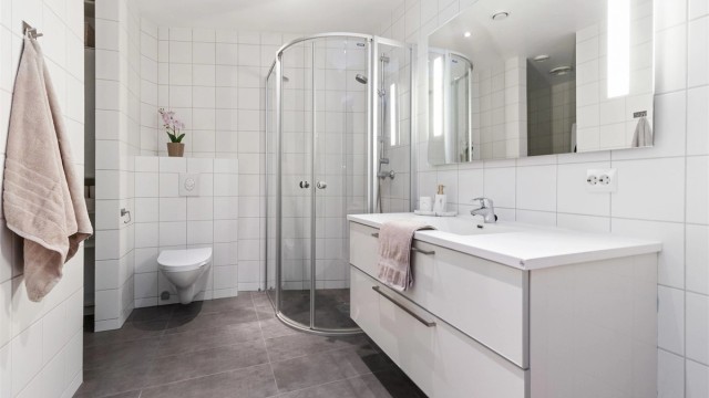 Flislagt bad i 1. etasje med praktisk innhugg til vaskemaskin og oppbevaring.