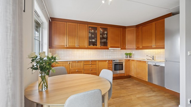 Boligen har en åpen stue- og kjøkkenløsning som skaper en luftig og sosial atmosfære, med gode møbleringsmuligheter og naturlig flyt mellom sonene. Ved vinduet er det god plass til spisegruppe – et lyst og trivelig samlingspunkt med rikelig naturlig lys.