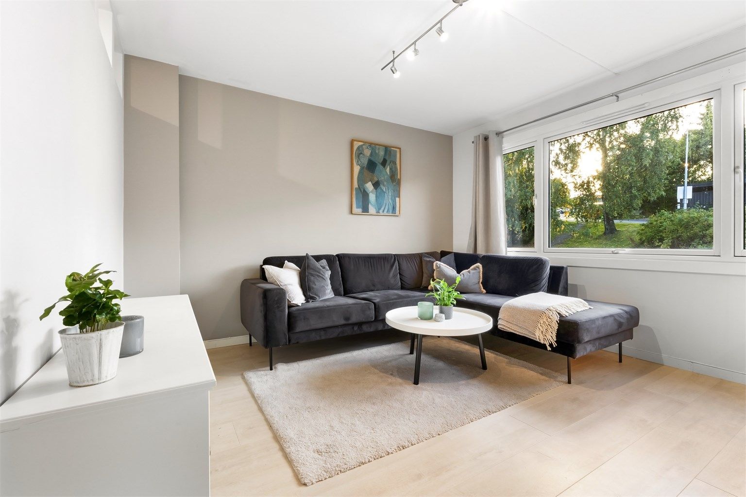 Stuen har plass til en romslig sofagruppe. Vinduene er fra 2008.
