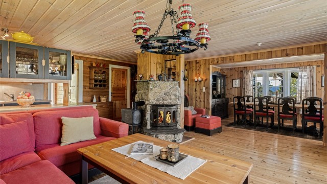 Hytta har en stor stue med både natursteinspeis med innsats og vedovn.