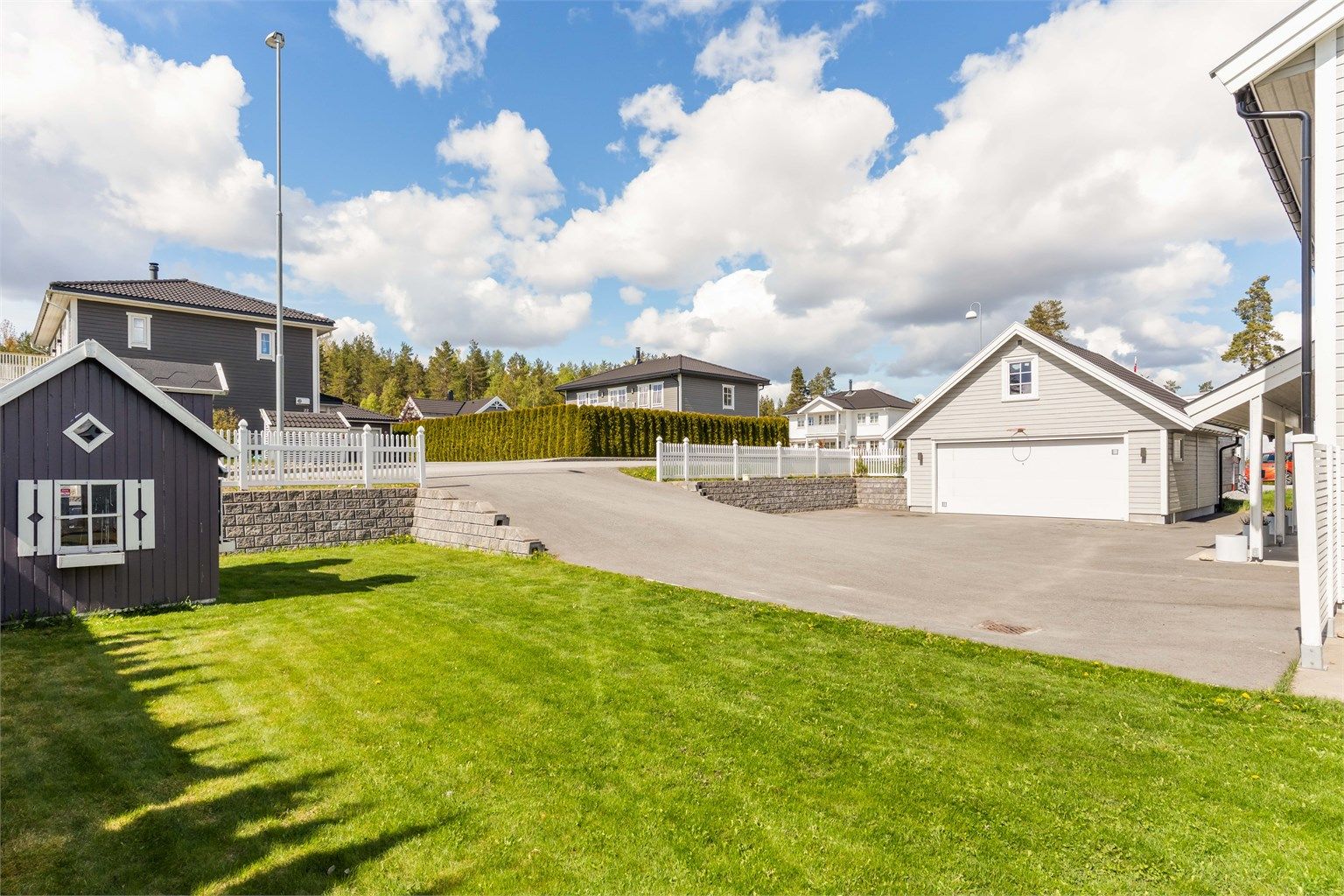 Romslig asfaltert gårdsplass med varmekabler mot garasje. 