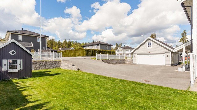 Romslig asfaltert gårdsplass med varmekabler mot garasje.