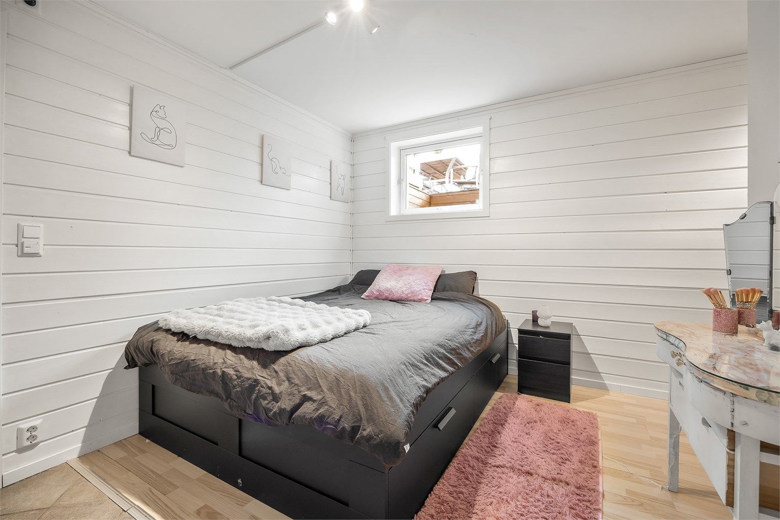 Soverom i utleiedelen med laminatgulv og malte panelvegger. Liten del av rommet er opprinnelig byggemeldt som bod.